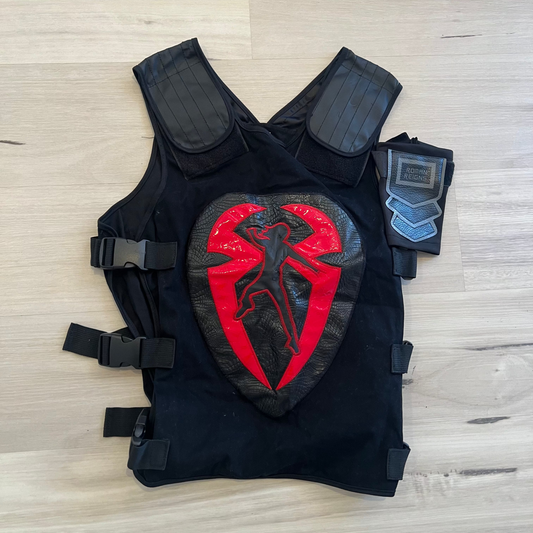 Black tactical vest with a red and black emblem on a light wooden surface